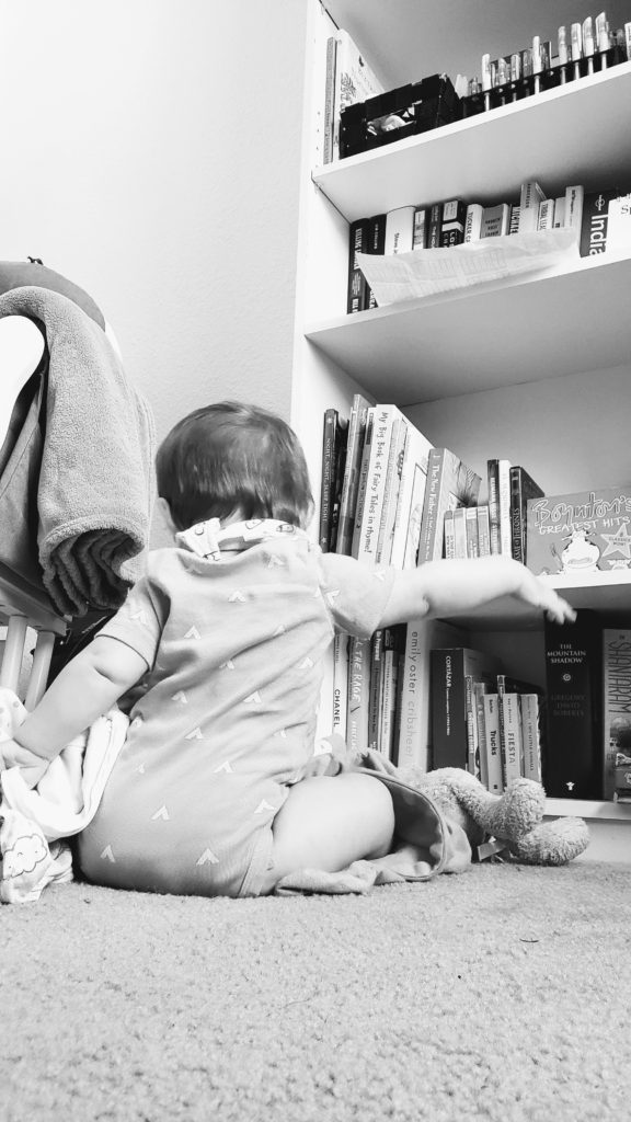 Baby in her room filled with books and more clothes than she could ever wear